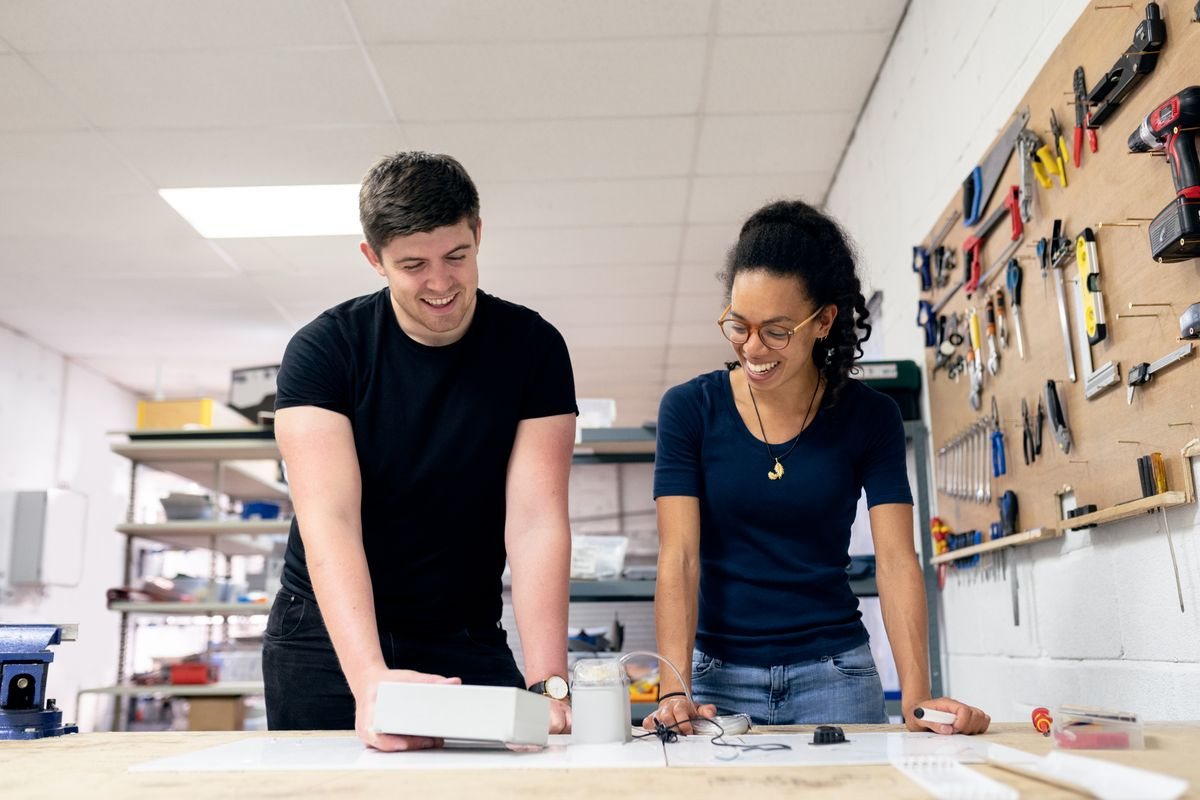 Zwei Personen besprechen an der Werkbank ein Bauteil